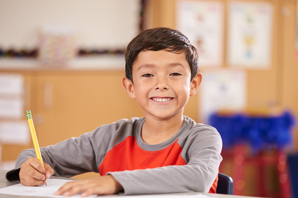 Smiling child writing at a desk